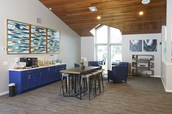 A kitchen with blue cabinets and a wooden ceiling.